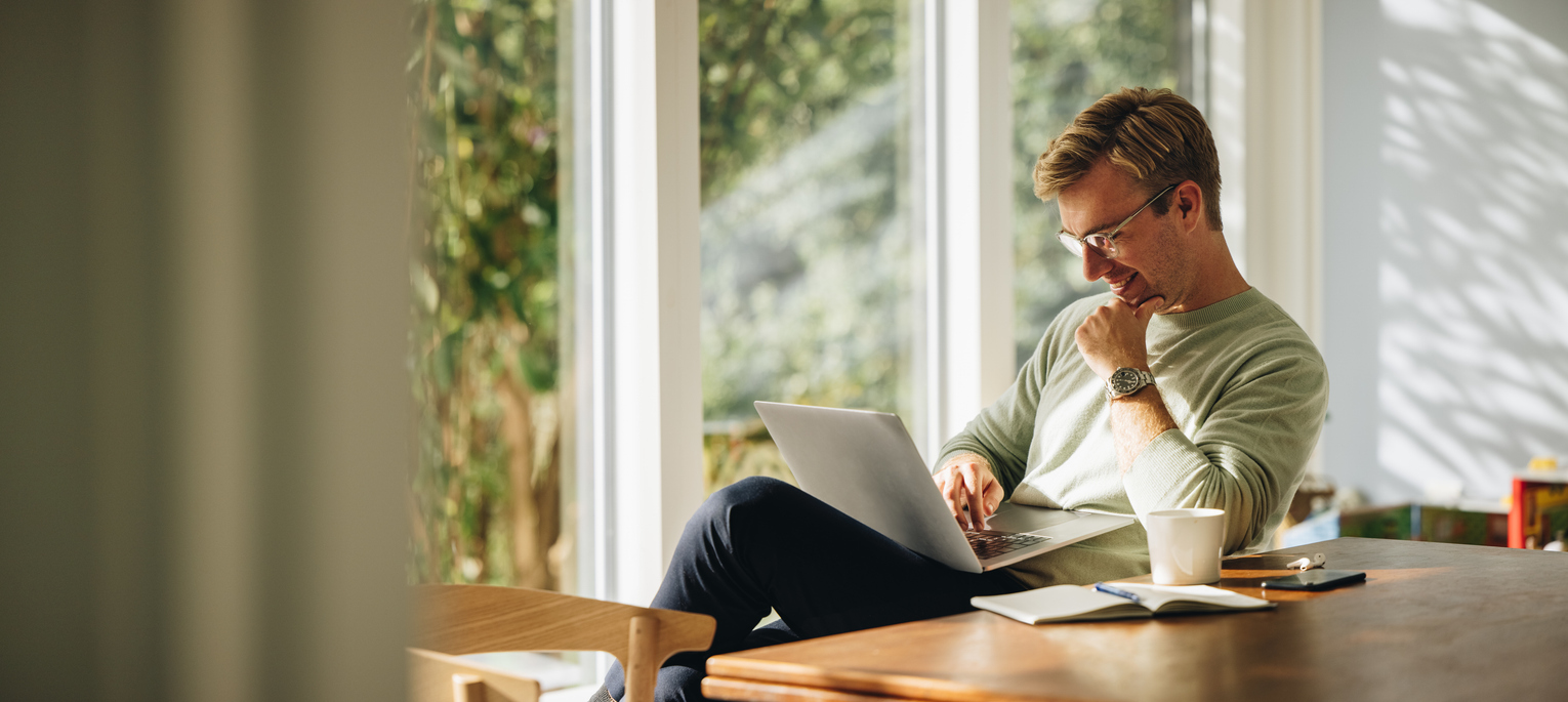 Young man using laptop and smiling